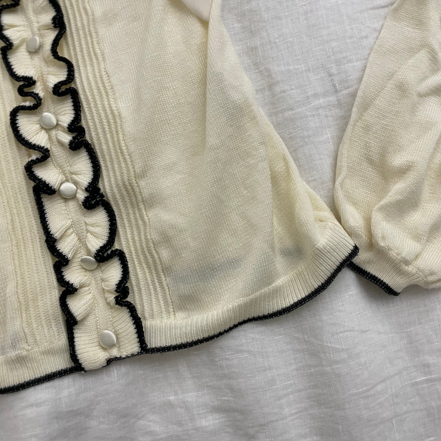 cream glacier long sleeve top with black lettuce trim and cream chiffon bow